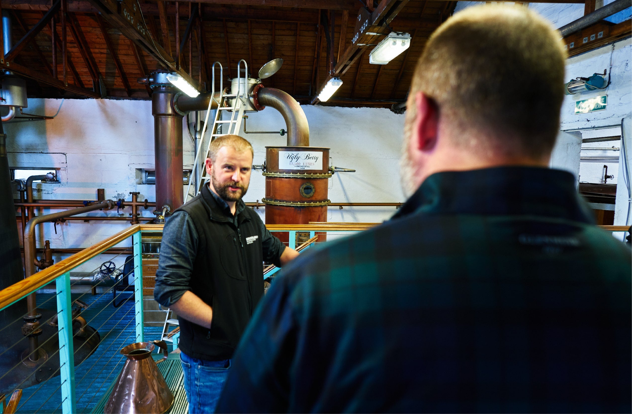 A photo of two men talking in a Botanist distillery