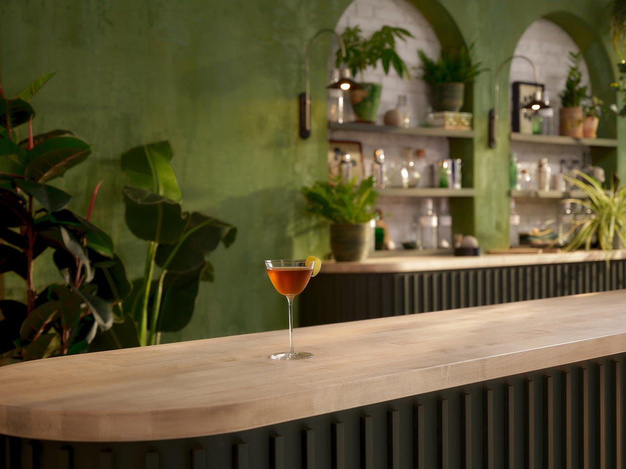 A lifestyle photo of a cocktail Perfect Martini on a counter in a bar